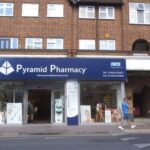 man looking at various tablets and supplements in pharmacy